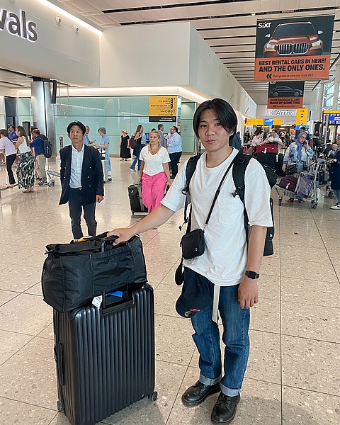 空港でスーツケースを持つ研修生