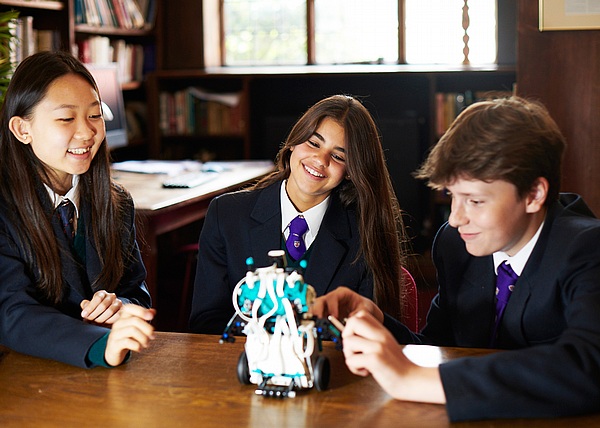 机の上で楽しく会話する学生たち